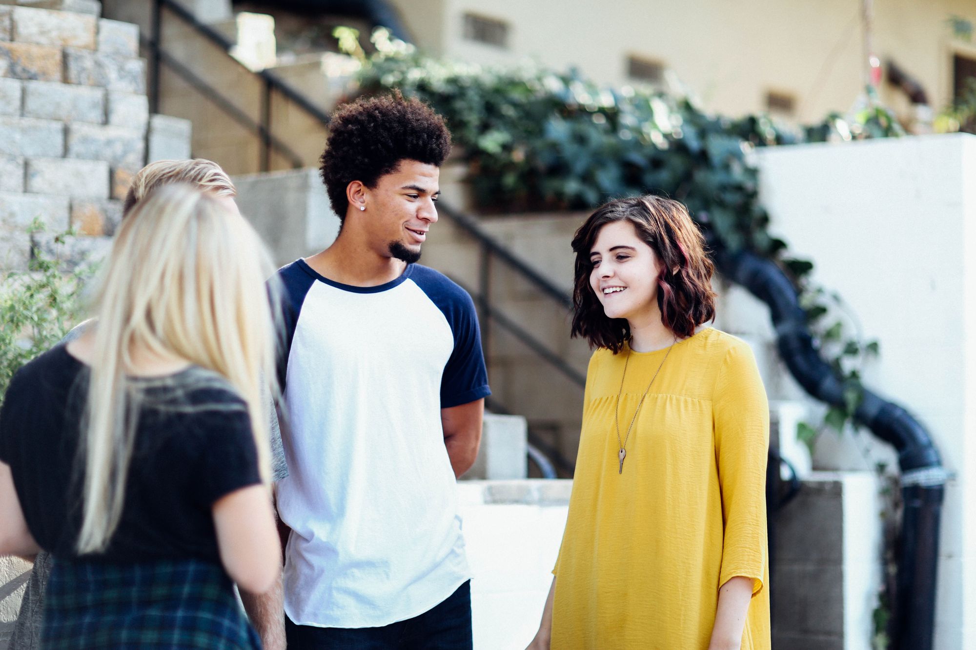 Três jovens conversam com escada ao fundo. Tema sugerido: portabilidade do plano de saúde